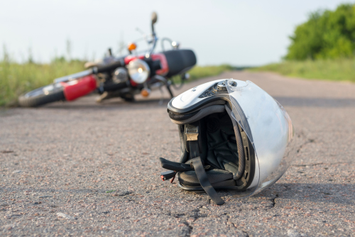 a motorcycle and a helmet on the ground after a motorcycle accident