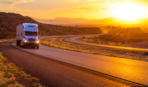 a truck on an interstate highway during sunset