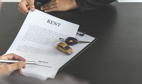 toy car and car key on top of a car rental agreement document